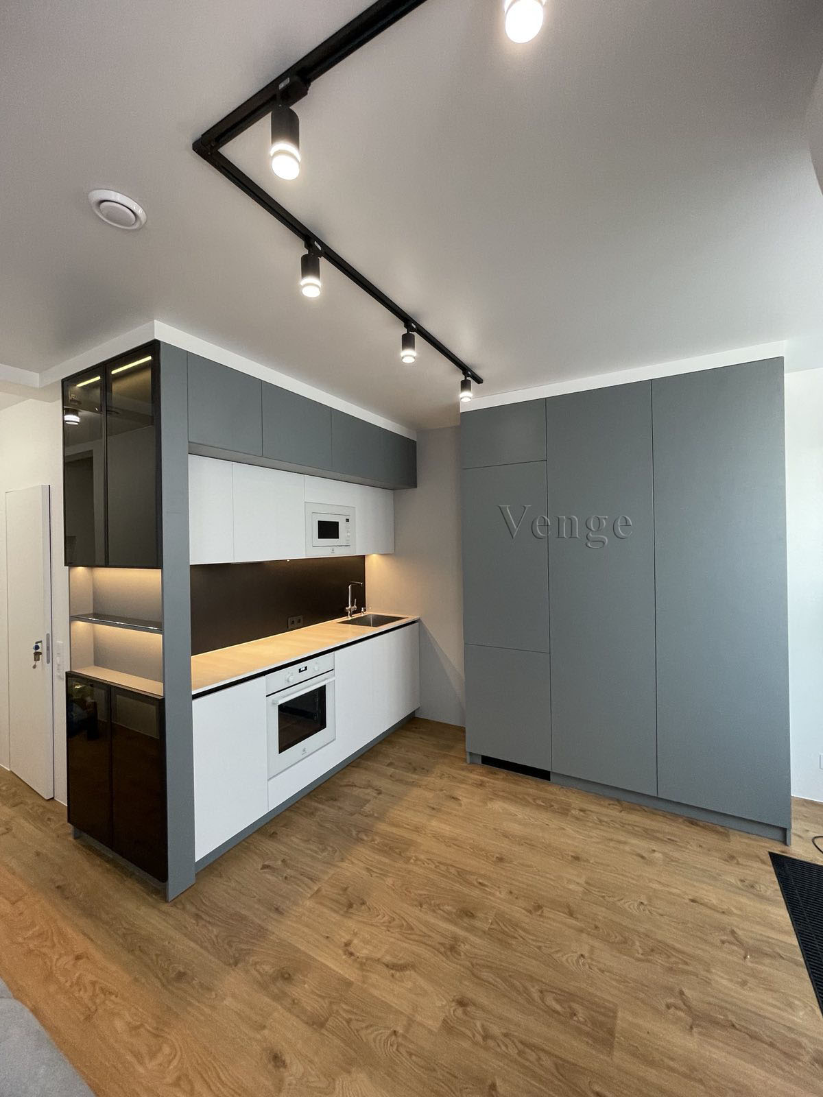 Integrated white kitchen wall joinery with timber detail