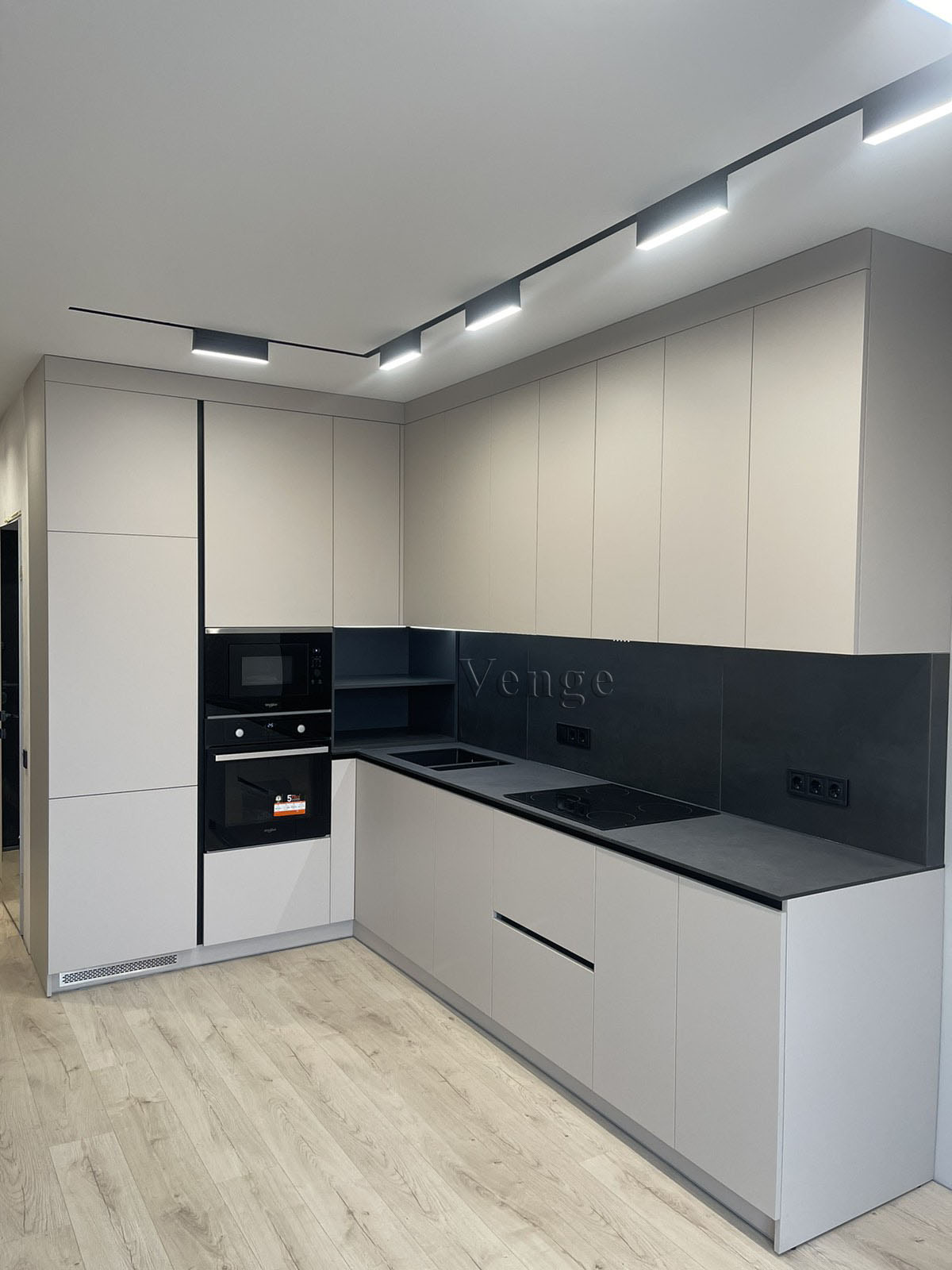 Long black and white kitchen joinery with integrated appliance tower