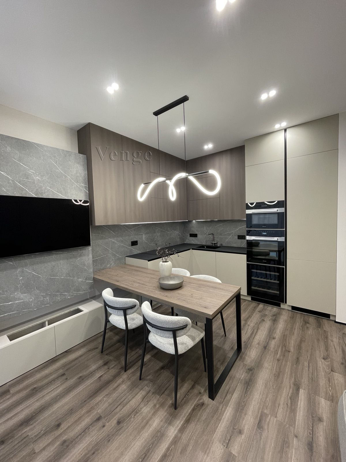 Modern kitchen and dining joinery with stone wall panels, timber overhead cabinets and integrated appliances
