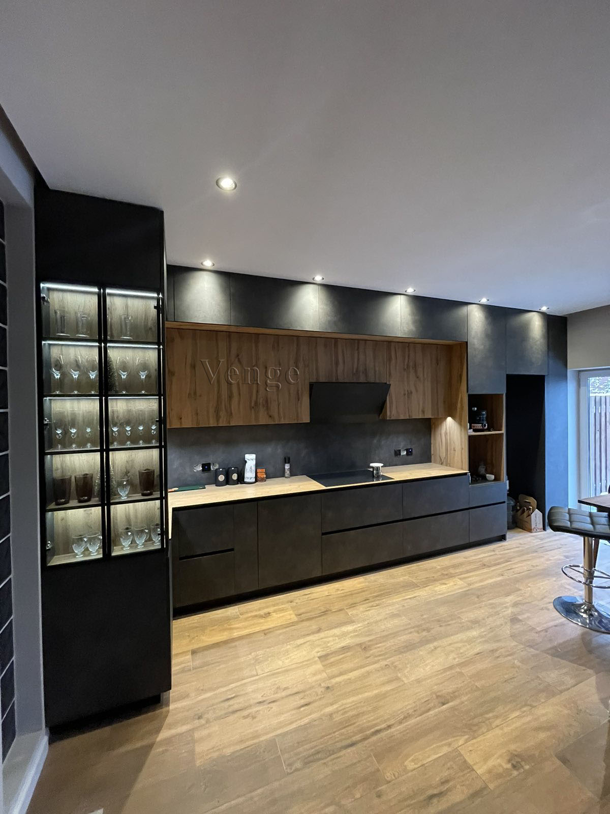 Dark colour kitchen with timber overhead cabinets and glass display storage