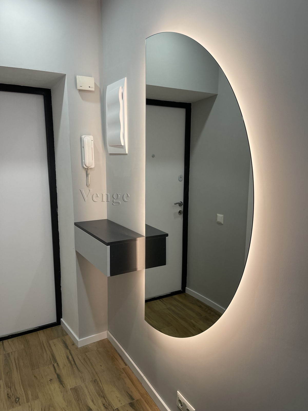 Wall-hung console joinery beside an illuminated oval mirror