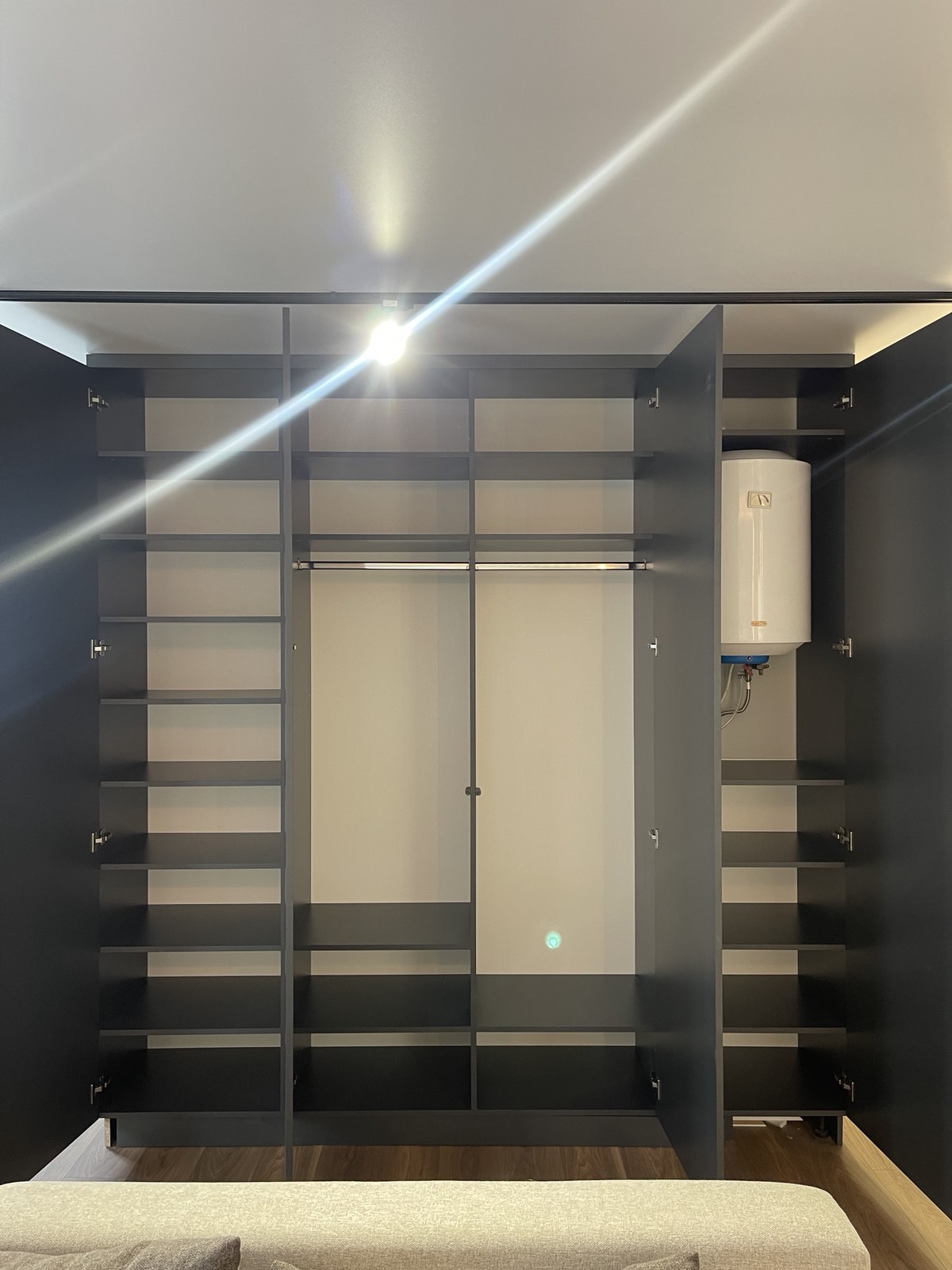Dark framed wardrobe room with open shelves and hanging space
